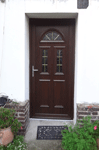 Porte d’entrée PVC chêne foncé avec vitrage demi-lune
